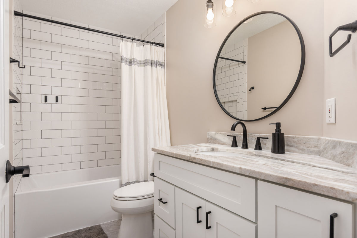 Bathroom renovation with new vanity mirror and subway tile shower with tub