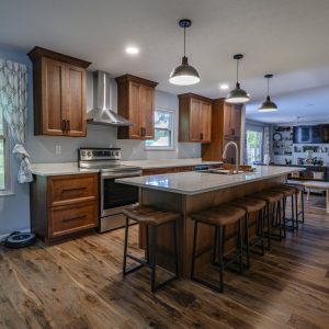 Remodeled-kitchen-with-new-wood-cabinets-island-stools-stove-and-range-hood